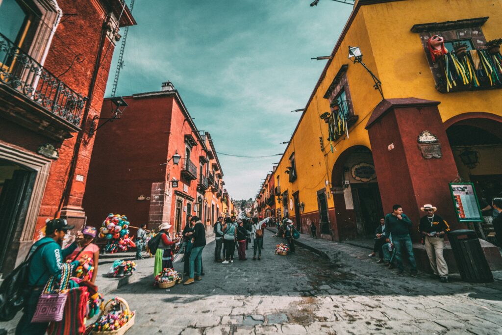 Various people walking and having conversations on a street in Mexico to show the diverse population.